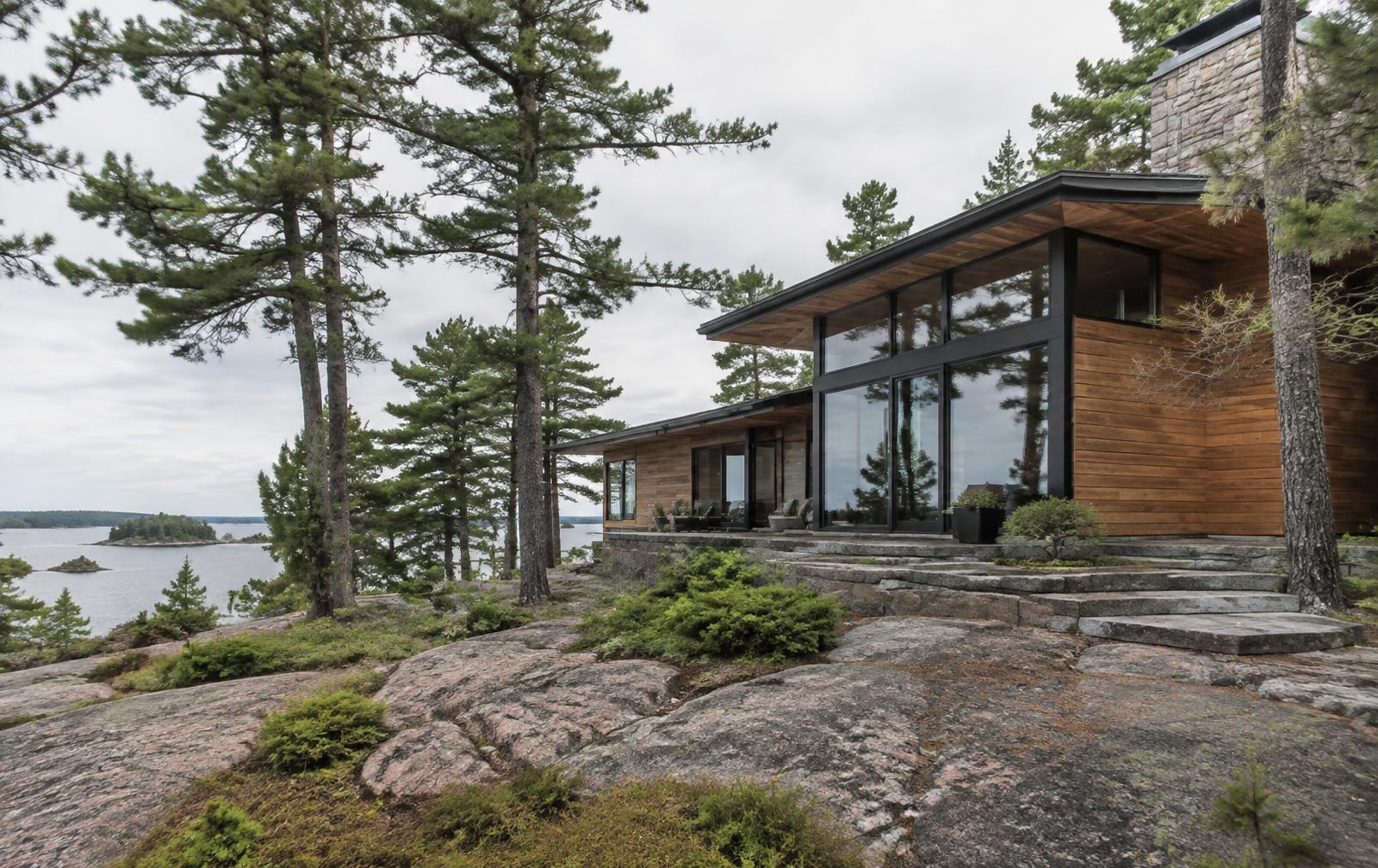 Caretaker visually checking the exterior of a cedar cottage near Georgian Bay